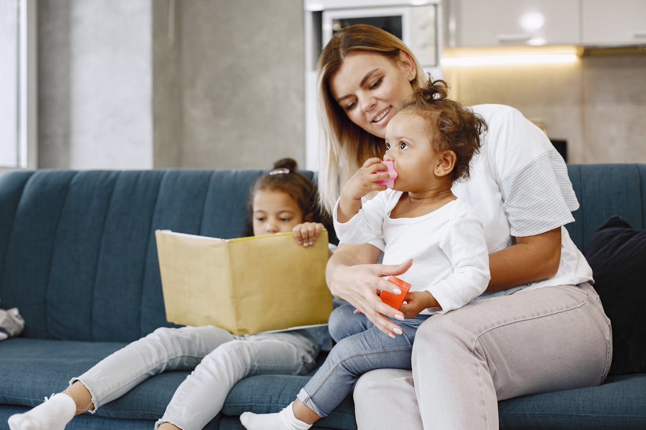 Mother and children sharing tender moments at home on a cozy couch.